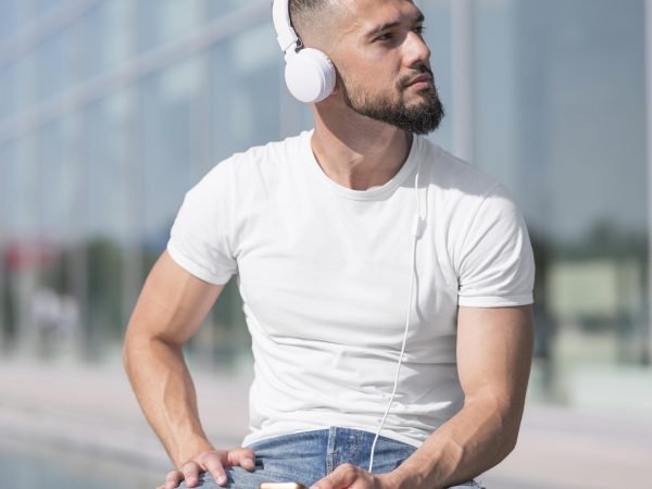 front-view-man-looking-away-while-listening-music